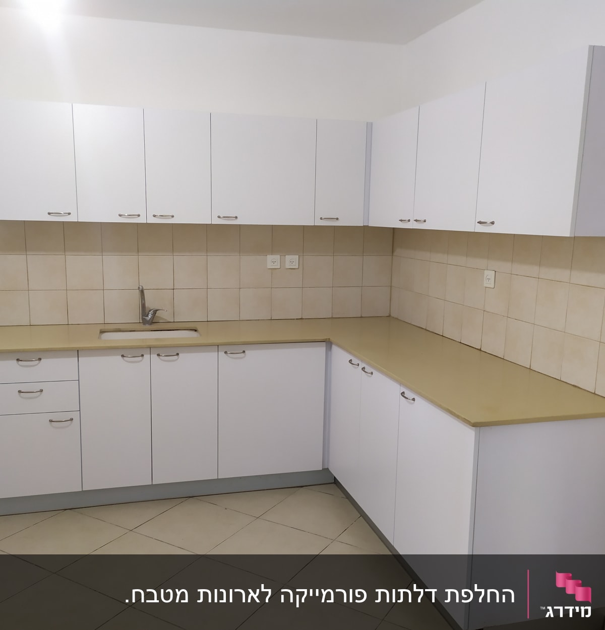 ארונות מטבח לבנים עם ידיות מתכת ומשטח עבודה